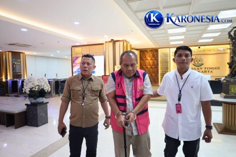 Tersangka korupsi proyek fiktif Ditjen Cipta Karya Kementerian PU rompi merah muda dengan tangan terborgol di Kejati Jakarta.