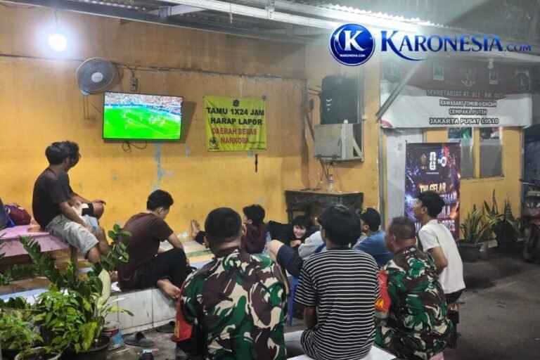 Anggota TNI dan warga menonton bersama pertandingan sepak bola di Jakarta Pusat.